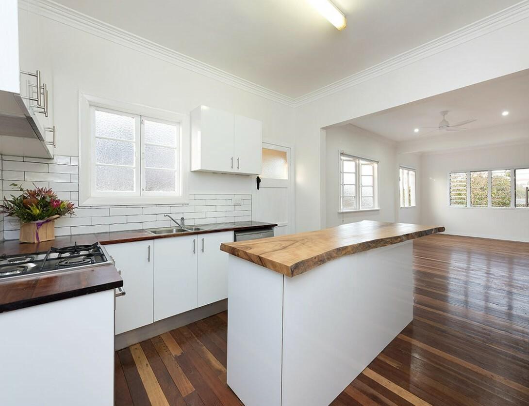 Jubilee Cottage kitchen with white cabinetry, timber island and polished floors